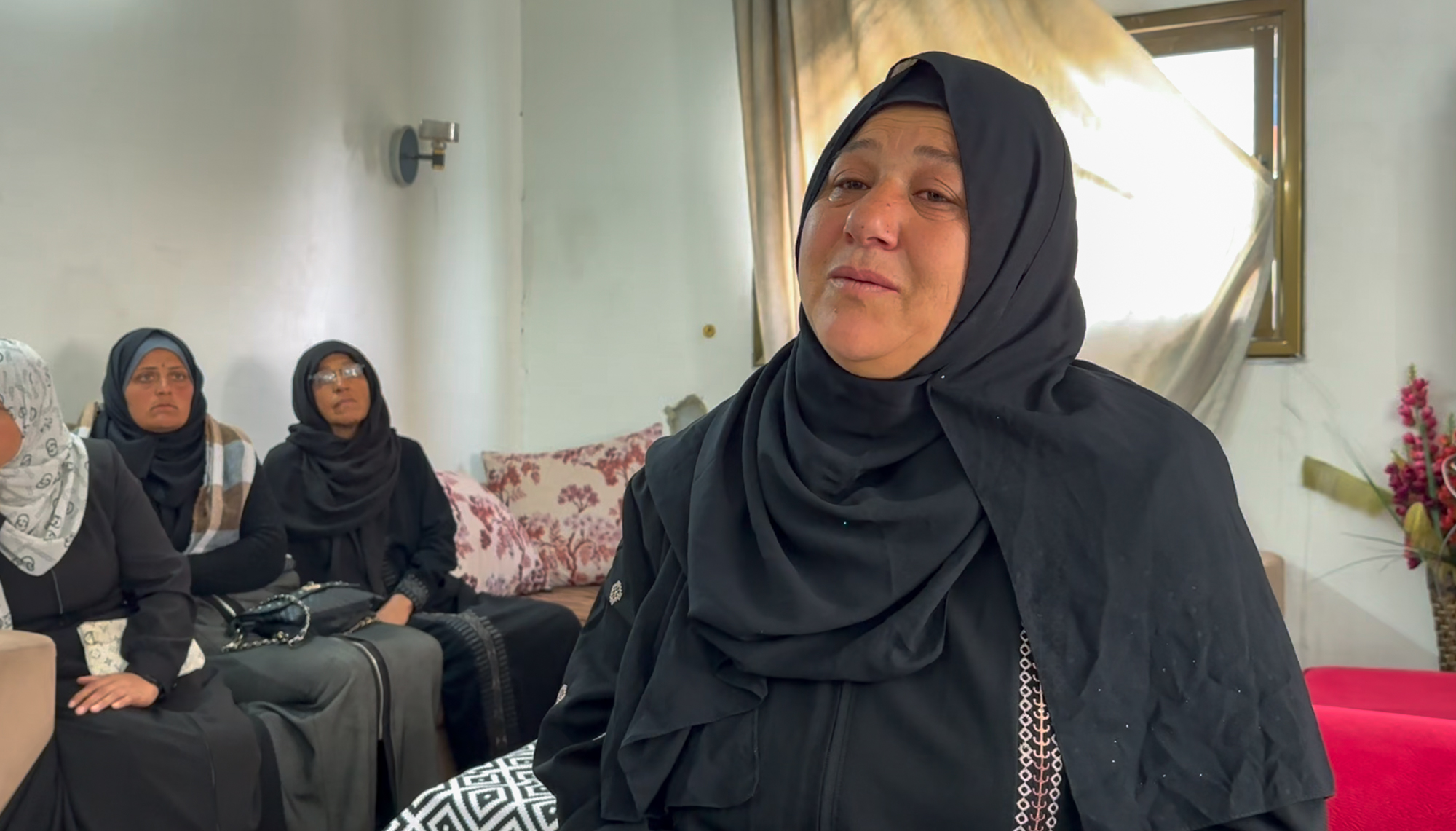 Amal, dressed in black, face puffy from crying